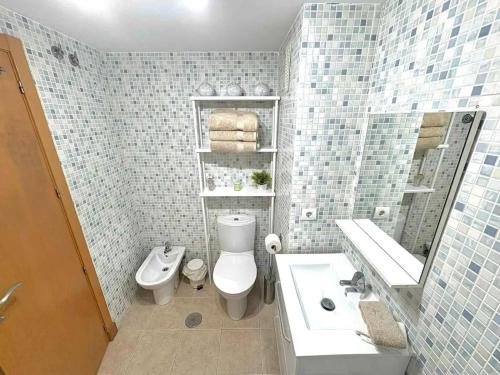 a bathroom with a toilet and a sink and a mirror at Bright apartment with sea view in Casares, 96 m², pool in Casares