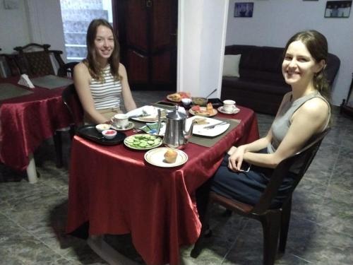 two women sitting at a table with food at Charlotte Inn in Kandy