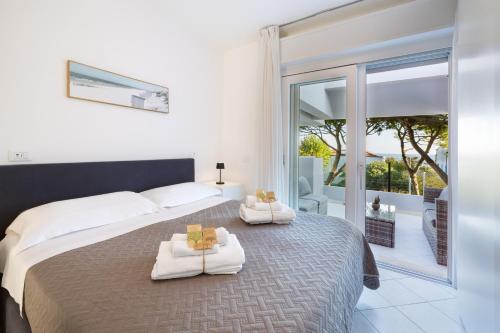 una camera da letto con un letto grande con asciugamani sopra di Carinzia Appartamenti - solo il mare davanti dal 1982 a Riccione