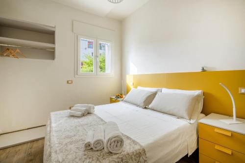 Gufo di Mare - Giallo في سافيلّيتري دي فاسانو: غرفة نوم بها سرير مع مناشف عليه