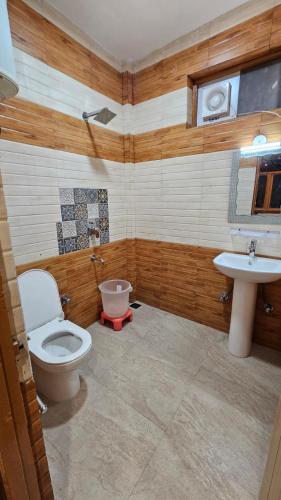 a bathroom with a toilet and a sink at Hotel Alpine Vista formerly Green View Hotel and Restaurant in Dharmsāla