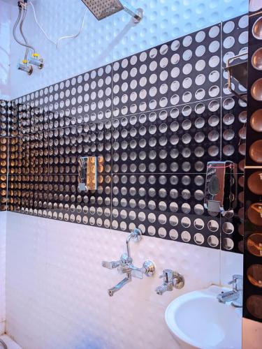a bathroom with two faucets and a sink at Hotel Pleasure Inn in Prayagraj
