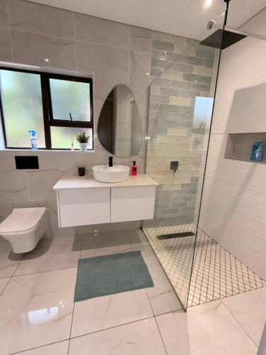 a bathroom with a sink and a toilet and a shower at Nobelina Guest House in Richards Bay