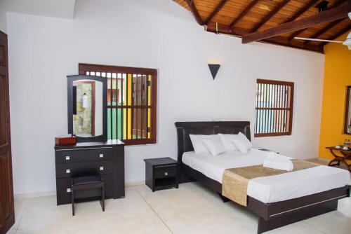 a bedroom with a bed and a dresser and a mirror at ABS Villa Bentota in Bentota