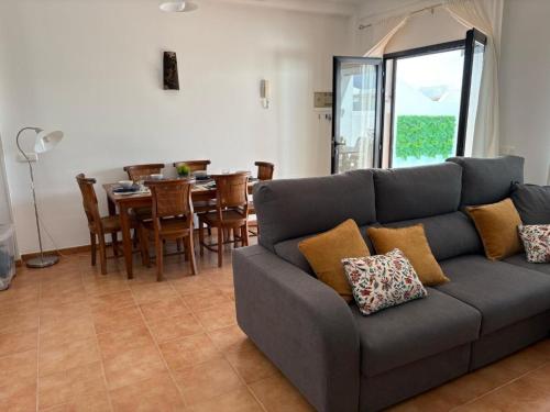 Una sala de estar con un sofá y una mesa con sillas. en Villa Vera, en Playa Blanca