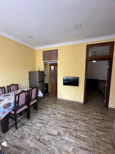 a dining room with a table and chairs and a television at Arpi GuestHouse Dilijan in Dilijan