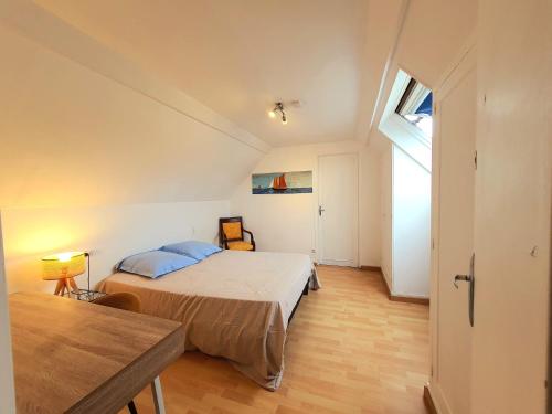 エヴルーにあるChambres chez l'habitant à louer 10 min gare et centre villeのベッドとテーブルのある寝室