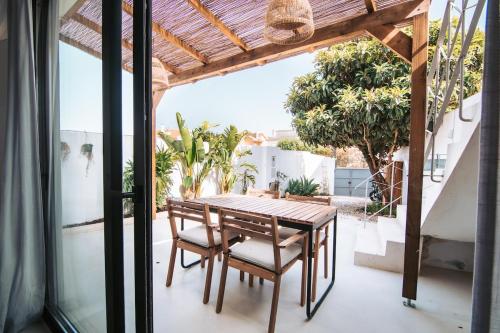 une table et des chaises en bois sur une terrasse dans l'établissement Casa Luma, à Cascais