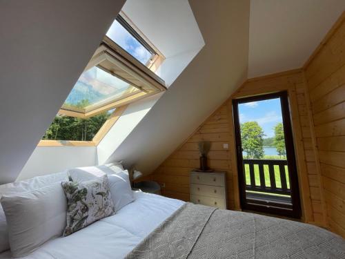 a bedroom with a bed and a large window at Mahoniówka Mikołajki in Wawrowice