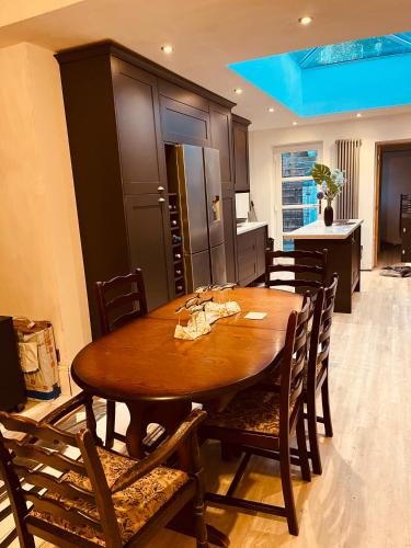 ein Esszimmer mit einem Holztisch und Stühlen in der Unterkunft Stylish & Spacious Victorian Home near Severn Valley Railway & Safari Park in Kidderminster