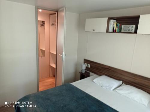 a small bedroom with a bed and a closet at mobil home in Sainte-Reine-de-Bretagne