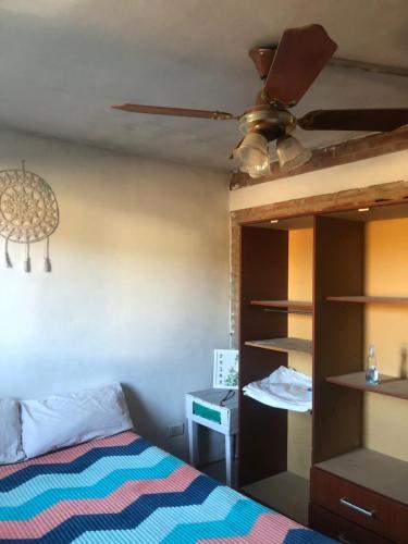 Arroyo de Los PatosにあるCasita El Mirador Traslaのベッドと天井扇風機のある寝室