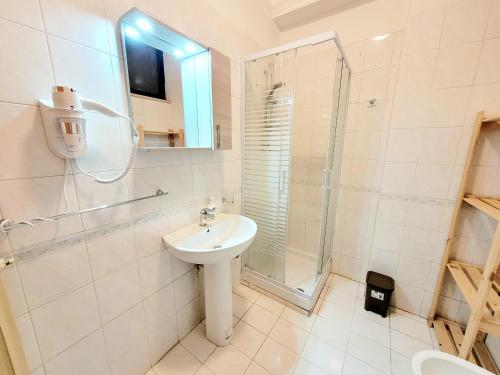 Un baño blanco con lavabo y ducha. en Casa Mary, en Nocera Inferiore