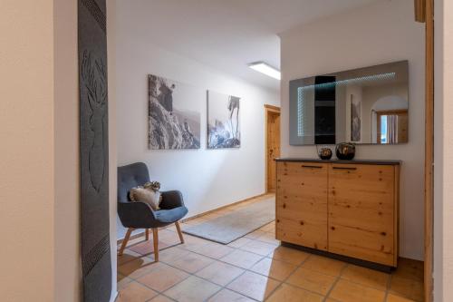 a living room with a tv and a chair at Penthouse Appartement in Kirchberg in Tirol