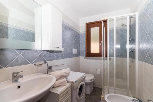 a bathroom with a sink and a toilet and a shower at Appartamento con piscina 14 in Trinità dʼAgultu