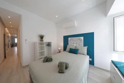 a bedroom with a large white bed with blue accents at Bouganvilia House in Tavira