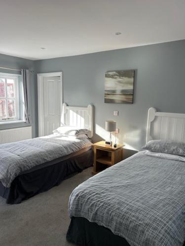 FreckenhamにあるThe Golden Boar Innのベッドルーム1室(ベッド2台、ランプ付きテーブル付)