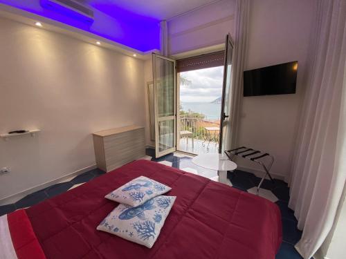 Un dormitorio con una cama roja y una gran ventana. en Hotel Vietri Coast, en Vietri