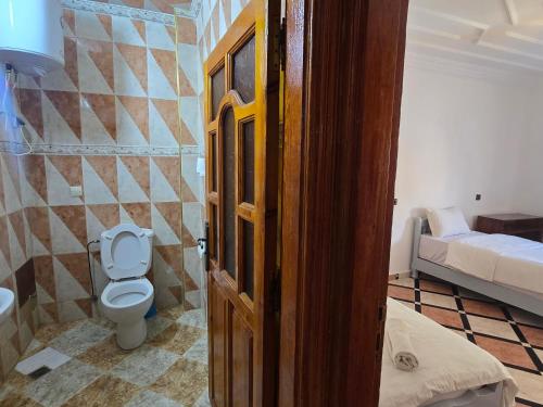 a bathroom with a toilet and a bed in a room at mouja taghazout in Taghazout