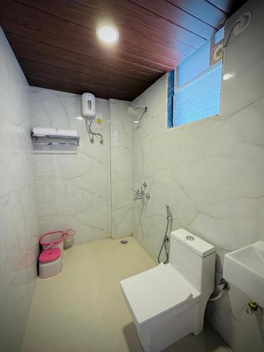 a bathroom with a white toilet and a sink at Seaside Beach Resort in Diveagar