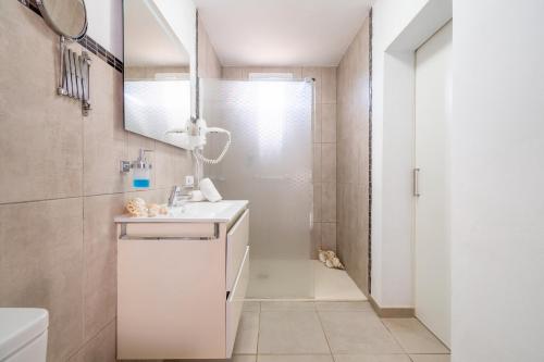a white bathroom with a shower and a sink at Son Bessó in Font de Sa Cala
