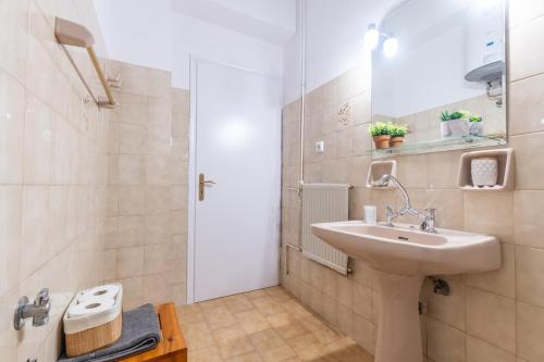 a white bathroom with a sink and a shower at Maestro Apartment in Gaios