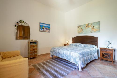 a bedroom with a bed and a table and a mirror at Casa Michela in Viddalba