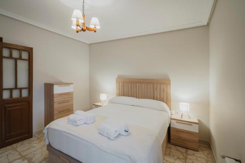 a bedroom with a white bed with towels on it at Casa Tilde in Matapozuelos