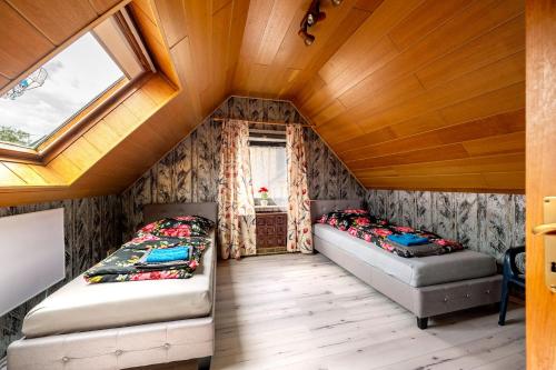 Dos camas en una habitación pequeña con ventana. en Ferienhaus Eiffelperle, en Kaisersesch