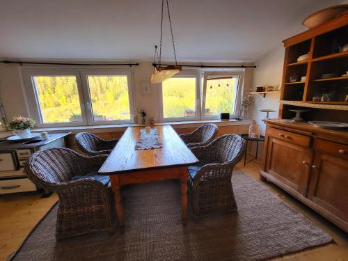 een eetkamer met een houten tafel en stoelen bij Ferienwohnung Schwarzwaldglück in Baiersbronn