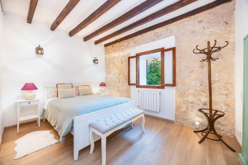 une chambre blanche avec un lit et une fenêtre dans l'établissement Son Burguet, à Puigpunyent