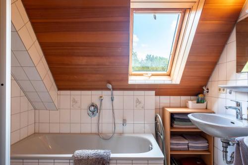a bathroom with a tub and a sink and a window at Hasenhof in Wolfach
