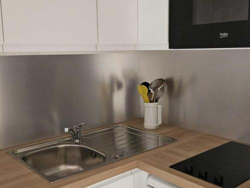 une cuisine avec un évier et un plan de travail dans l'établissement Appart 4 pers avec WIFI, animaux admis, proche pistes - Les Menuires - FR-1-574-66, aux Menuires