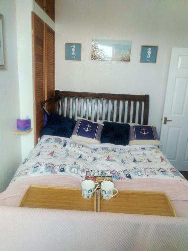 a bedroom with a bed with two cups on it at Seaview Smuggler Cove Cleethoropes in Cleethorpes