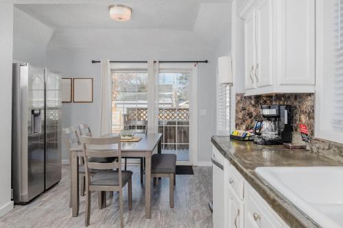 a kitchen with white cabinets and a table and chairs at Bungalow on Baldwin - 3 bed 2 bath in Oshkosh