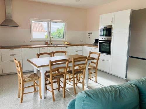 a kitchen with a table and chairs in a kitchen at Casa Elo - Fresh-Built Home with Pool in Alcorochel
