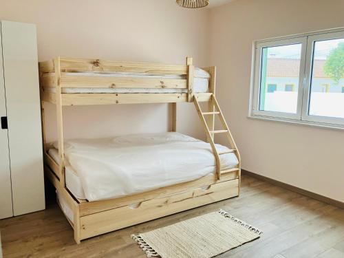 a wooden bunk bed in a room with a window at Casa Elo - Fresh-Built Home with Pool in Alcorochel