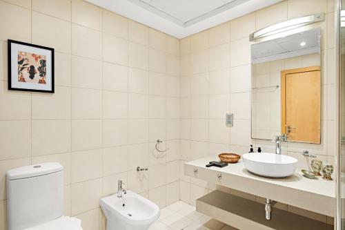 Un baño blanco con lavabo e inodoro. en VayK - Beachfront 1BR with Sea Views in Palm Jumeirah, en Dubái