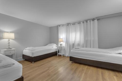 a bedroom with two beds and a table with a lamp at Castle Inn Apartments - Downtown Keflavík in Keflavík