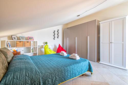 een slaapkamer met een bed met een blauwe deken bij Non dire Gatto - Elegant Rooftop in Alghero
