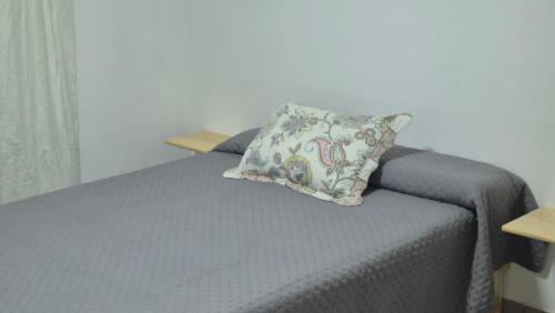 a bedroom with a bed with a pillow on it at Delvi Nelly - Belgrano in Neuquén