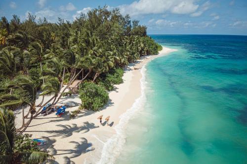 an aerial view of a beach with palm trees and the ocean at Four Seasons Resort Seychelles at Desroches Island in Desroches