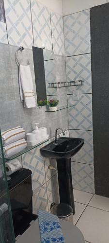 a bathroom with a black sink and towels at Casa de Jovan in Cairu
