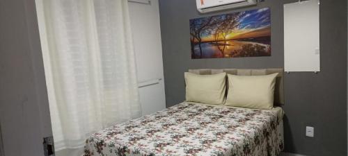 a bedroom with a bed and a painting on the wall at Casa de Jovan in Cairu