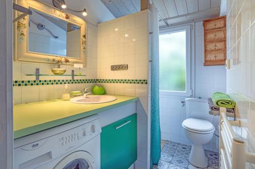 LʼÉpineにあるGîte tout confort 500m plageの洗面台と洗濯機を備えたバスルーム