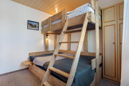 a bunk bed room with two bunk beds and a ladder at Ferienbungalow Meerjungfrau in Ueckermünde