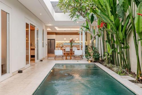 - une piscine intérieure dans une maison avec salle à manger dans l'établissement Villa Vana, Sitara Villa Group, à Seminyak