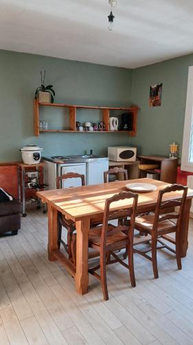 Un comedor con mesa y sillas de madera. en Chambre étudiant, en Coutances