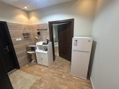 Una pequeña cocina con fregadero y refrigerador. en Waha Grand Residance, en Medina