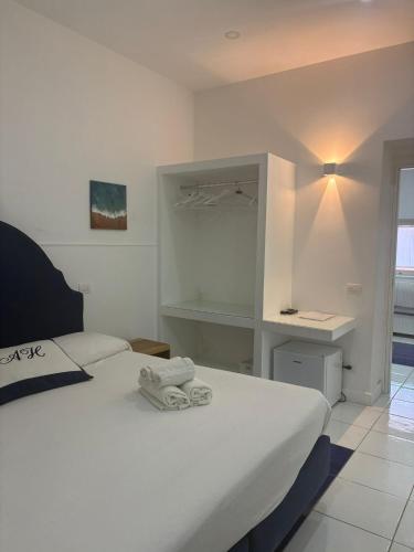 een witte slaapkamer met twee handdoeken op een bed bij Abagnale Home Sorrento in Sorrento
